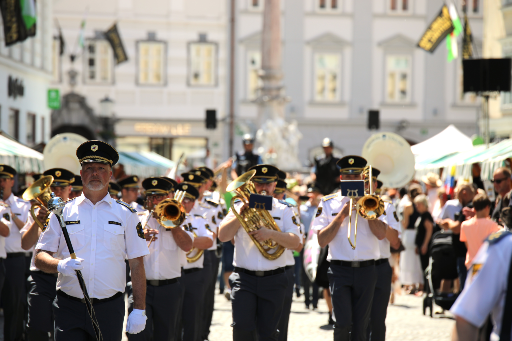 Policijski orkester z dirigentom na čelu igra na ulici.