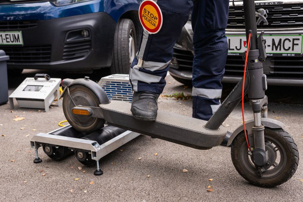Policist s posebno napravo preverja e-skiro.