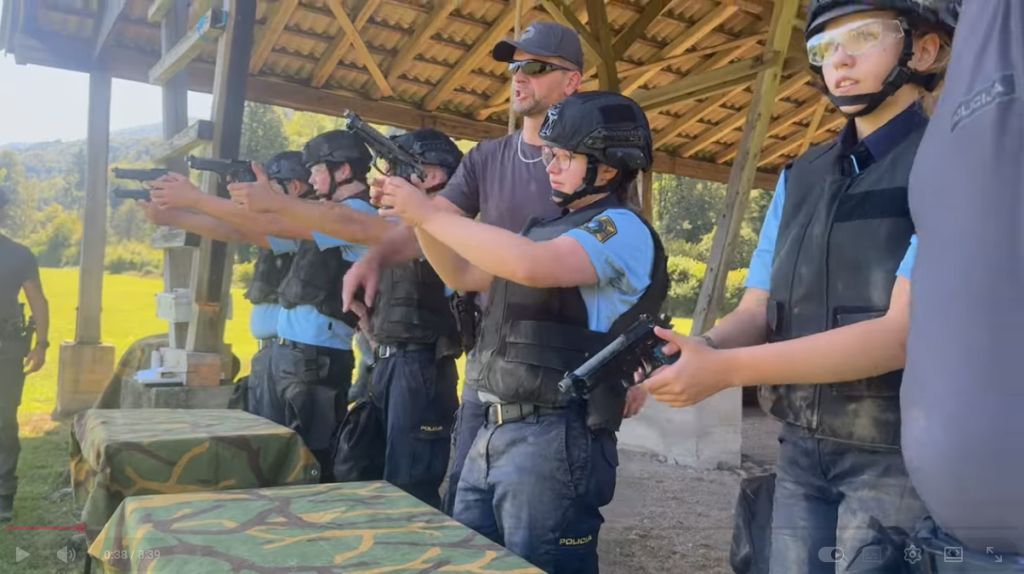Izrez iz videa, ki prikazuje udeležence med rokovanjem z orožjem
