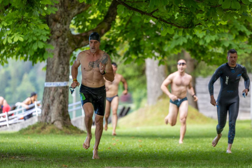 Tekmovalci tečejo po plavanju v jezeru