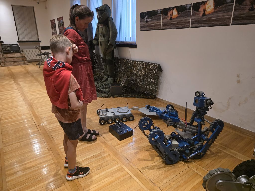 Obiskovalca si ogledujeta robota za protibombno zaščito.