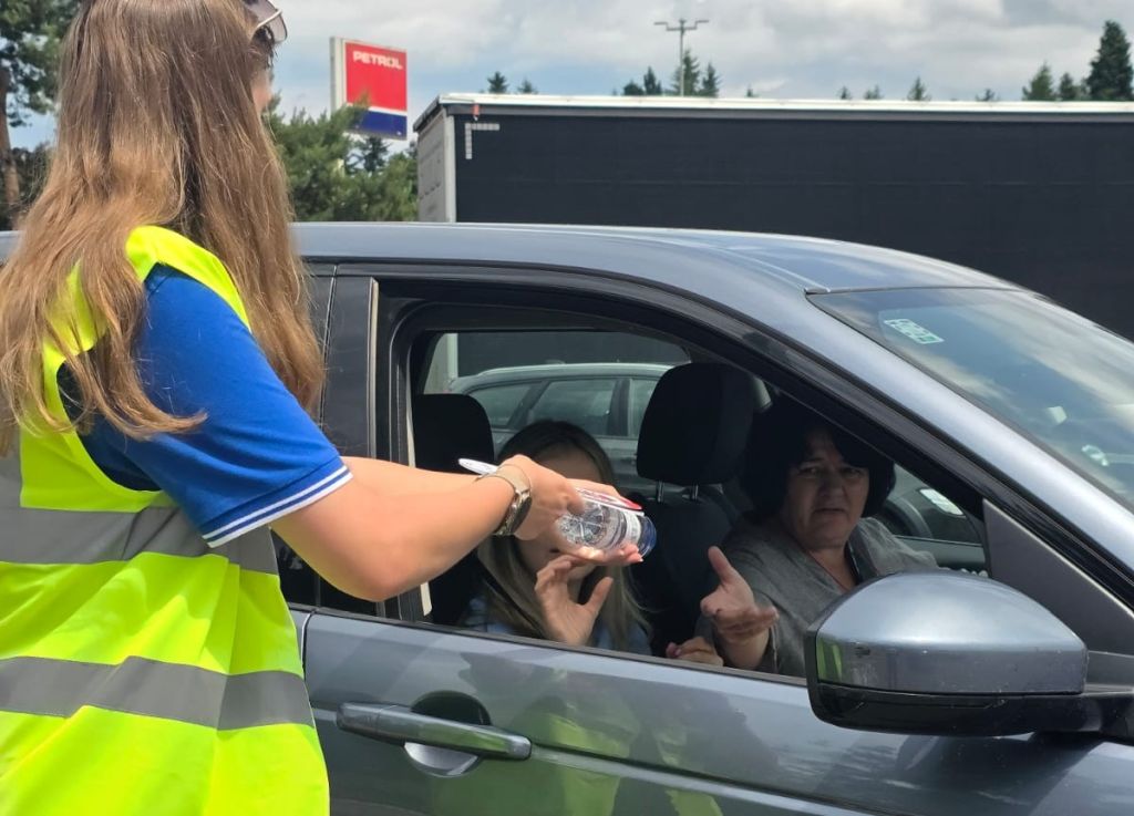Promotorka izroča plastenko vode voznici