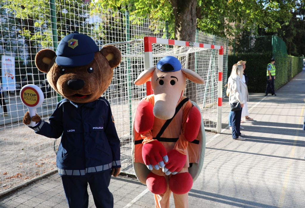 Maskota Policije maha s stop loparčkom, ob njem stoji maskota AVP