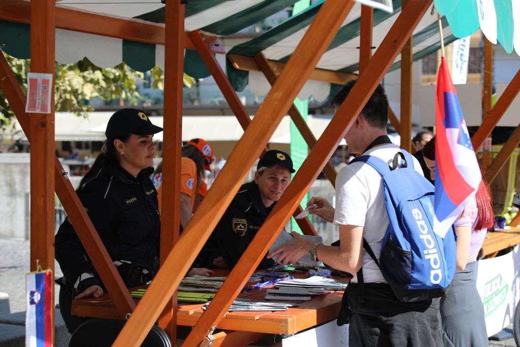 Policistki se pogovarjata z obiskovalci ob policijski stojnici