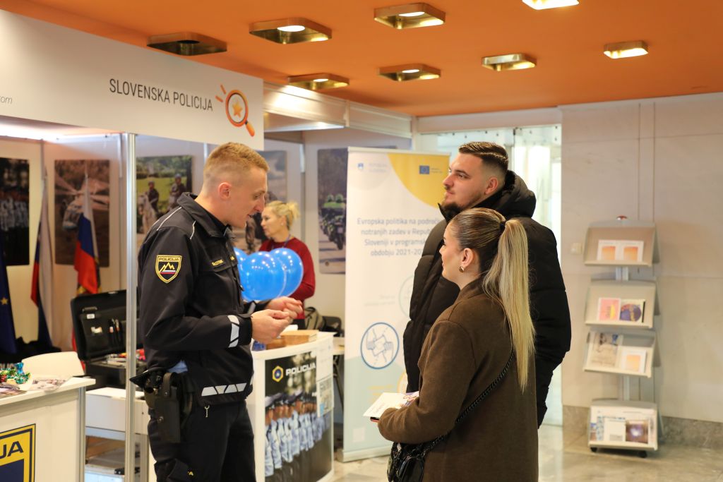 Obiskovalca se pogovarjata s policistom na policijski stojnici v Cankarjevem domu.