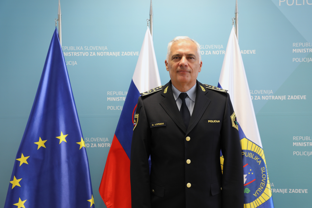Danijel Lorbek, v ozadju so zastave.