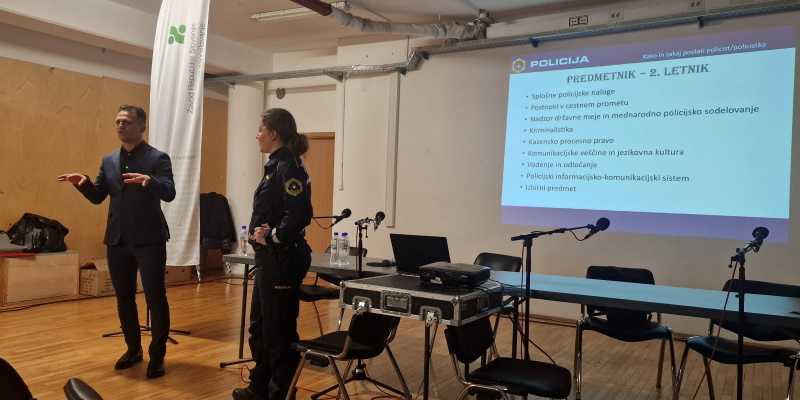 Policista v predavalnici med predstavitvijo šolanja v policiji