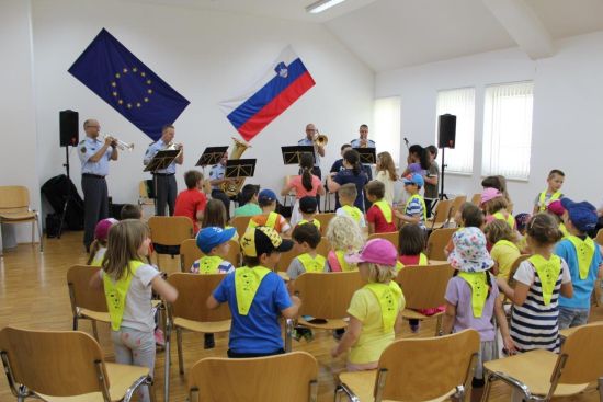 slika z nastopa kvinteta Policijskega orkestra in mladimi poslušalci