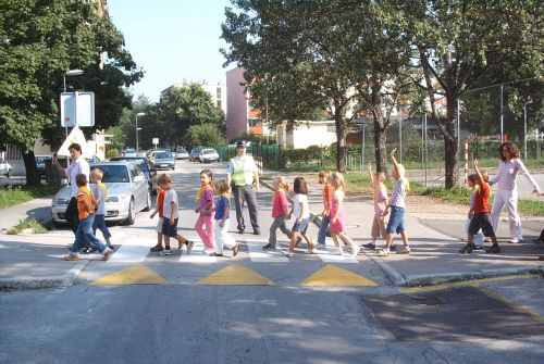 picture of a policeman ensuring the safe passage of children across the zebra crossing