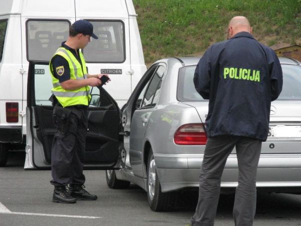 slika dveh policistov, ki pregledujeta vozilo