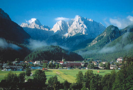 picture of a village, with mountain peaks in the background