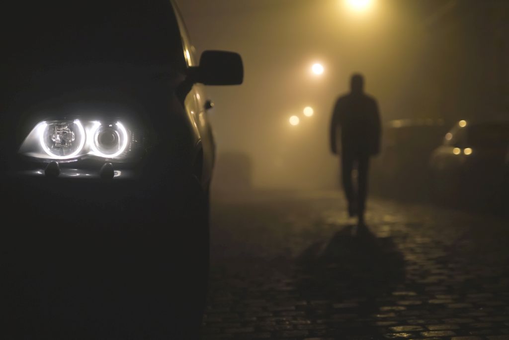 silhouette of a person in dark clothes on the road in the dusk