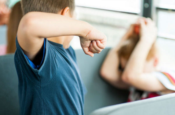 picture of an aggressive child who wants to hit a peer