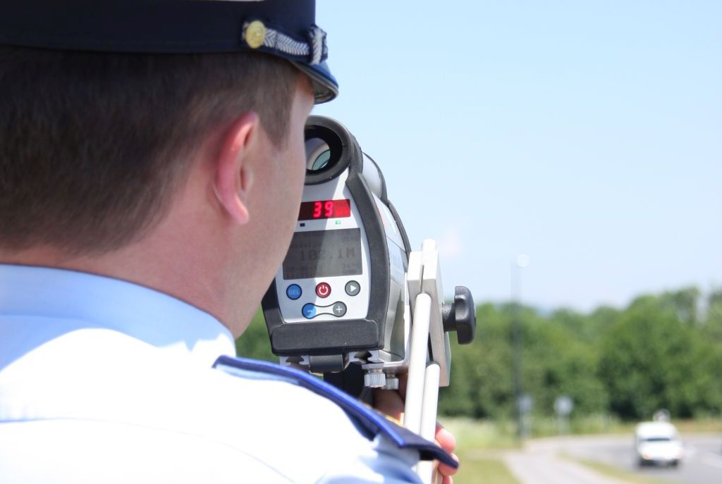 picture of a police officer with a radar gun, measuring speed