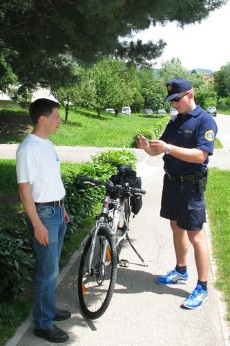 picture of a police cyclist checking a pedestrian